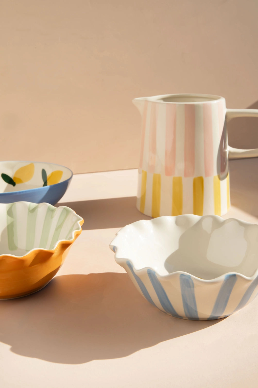 Orange scalloped bowl with aqua green stripes and heart outline in hand-painted glazed stoneware