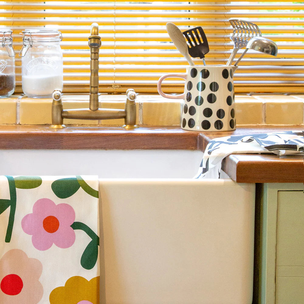 Mono Spot glazed stoneware pitcher with black and white polka dots and a pink handle